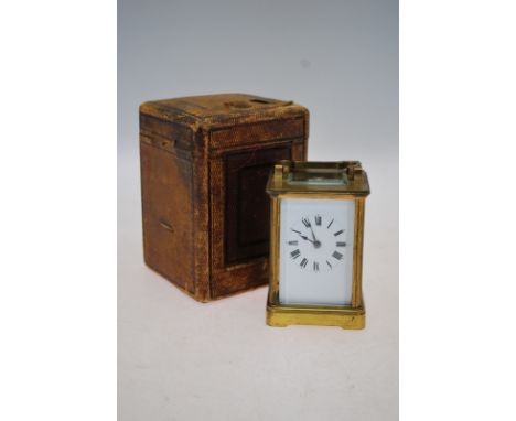 A brass carriage clock striking on a coiled gong with enamel dial and bevelled glass panels, with leather travel-case Conditi