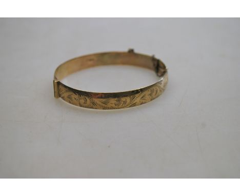 A 9ct half-engraved hinged bangle, with safety chain attached, approx 22g 