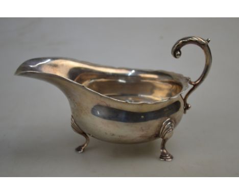 An Edwardian silver sauce boat with cut rim, scroll handle and hoof feet, Haseler Bros., London 1901, 4.6 oz