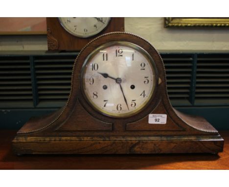 A 1930's oak 'Admiral Hat' style mantel clock, the beaded and panelled case with silvered dial enclosing an English twin trai