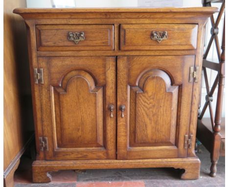 A small oak side cabinet, with short drawers over arch panelled doors on bracket feet, 77cm wide