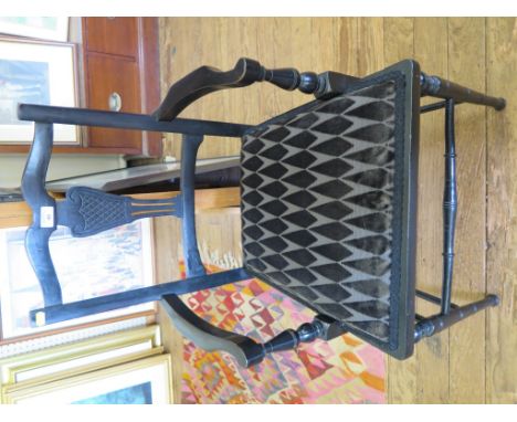 A pair of Edwardian ebonised open armchairs, the scroll top rails over vase shaped splats, upholstered seats and turned legs 