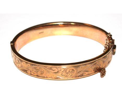 A ladies gold bangle with bright cut decoration