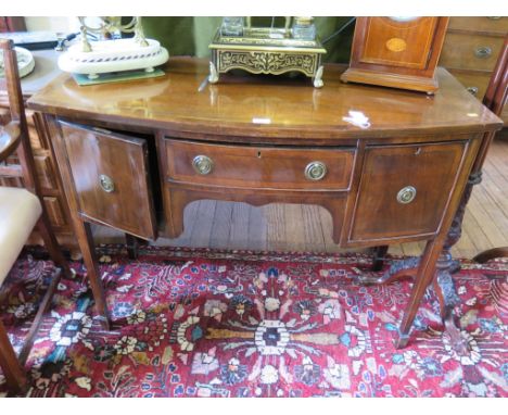A late George III style crossbanded mahogany bowfront sideboard with ebony stringing, the central drawer flanked by a deep dr