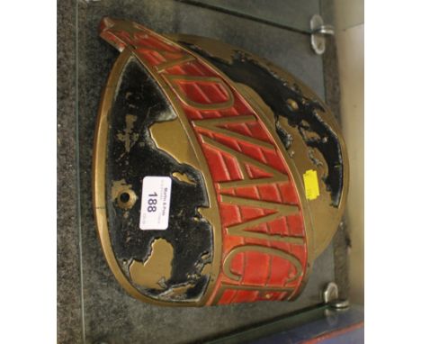 A painted brass curved traction engine plaque depicting the world and inscribed Advance 26cm wide, a brass spirit level, a Sc