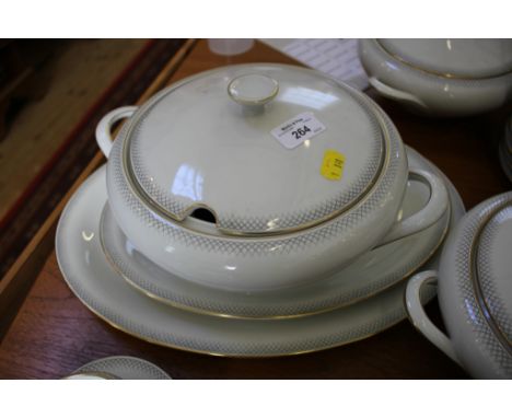 A Tirschenreuth part dinner service, with gilt rims and arch pattern border, including three tureens and covers