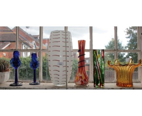 A pair of blue glass candlesticks, a large white vase, and three other coloured glass vases