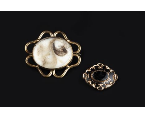 TWO VICTORIAN MEMORIAL BROOCHES, the first with an oval hairwork panel and openwork border, the second with gilt inscription 