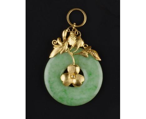 A JADE ANNULAR PENDANT, the circular jade panel with central cloverleaf and part-textured foliate surmount, yellow precious m