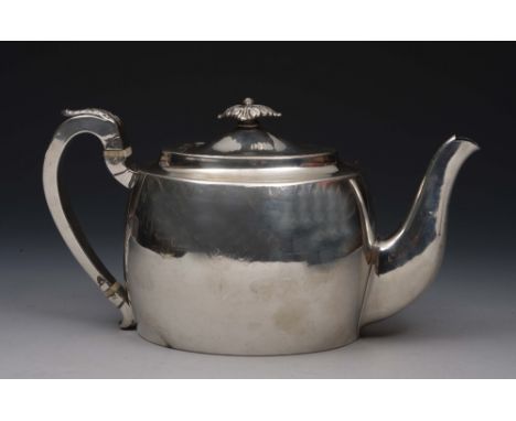 A GEORGE III SILVER TEAPOT of plain oval form with a matching domed lid, 'C' scroll handle with acanthus leaf decoration and 