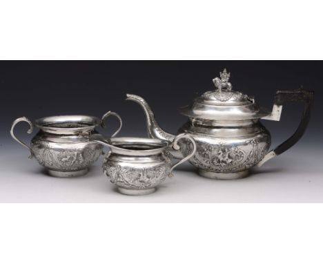 AN ANGLO INDIAN THREE PIECE TEA SET, the teapot chased with a scene of St George slaying the dragon and Indian hunting scenes