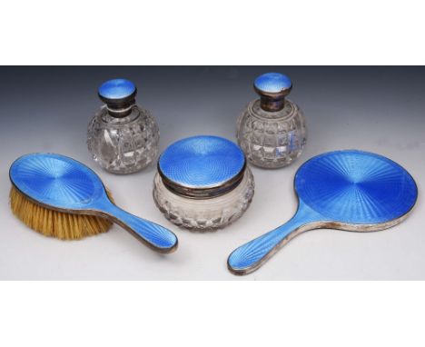 A FIVE PIECE SILVER AND BLUE ENAMEL DRESSING TABLE SET TO INCLUDE: a mirror, hairbrush, two cut glass scent bottles and a pow