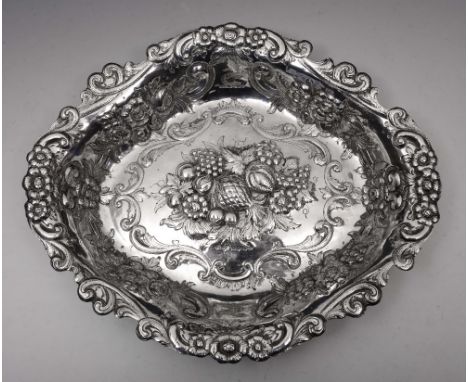 A GEORGE III SILVER OVAL SHAPED DISH with a chased foliate and scroll decorated edge and later chased foliate, scroll and fru