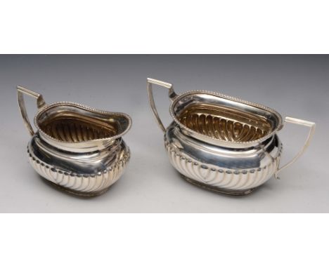 AN OVAL SHAPED TWO HANDLED SUGAR BASIN with reeded lower body, 17cm wide, with matching jug, Sheffield 1924 by The Cooper Bro