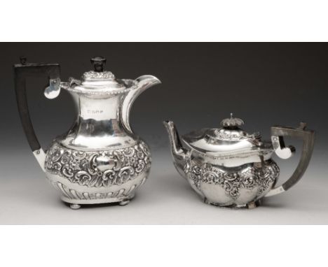 A LATE VICTORIAN OVAL SHAPED SILVER TEAPOT with panelled sides and chased scroll and foliate decoration, ebonised handle and 