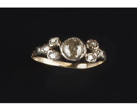 A DIAMOND DRESS RING, the principal old brilliant-cut diamond collet set between openwork shoulders of graduated cushion-shap