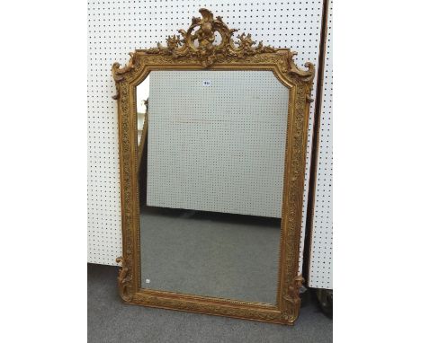 A late 19th century gilt framed overmantel mirror, the opposing 'C' scroll crest centred by a cherub playing a flute, above a
