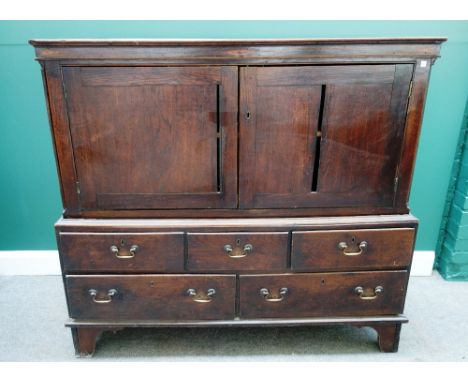 An 18th century bacon cupboard, with a pair of doors over five various drawers, on bracket feet, 134cm wide x 126cm high.