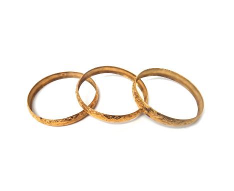 Three gold circular bangles, each having engraved decoration and detailed 18 K, combined weight 39 gms.