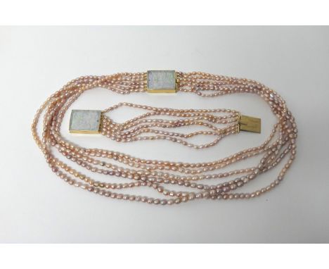 A six row necklace of pink tinted freshwater cultured pearls, on a 9ct gold mounted rectangular carved jade clasp, having a f