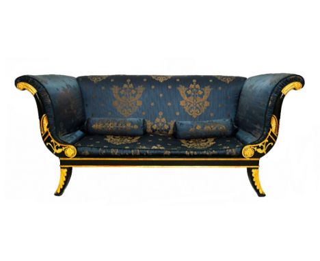 A Regency style parcel gilt ebonised sofa, with outswept arms and splayed supports, 207cm wide. Illustrated
