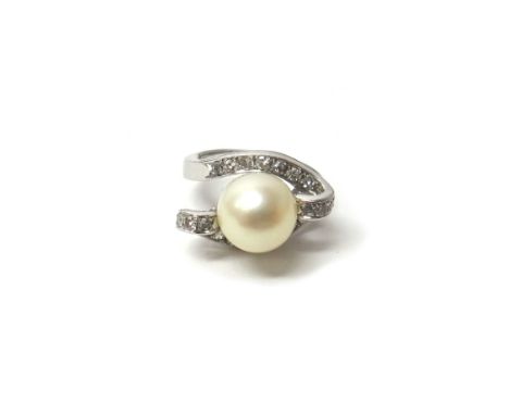 A white gold ring, mounted with a cultured pearl at the centre, between diamond set twist over sides, set with circular cut d