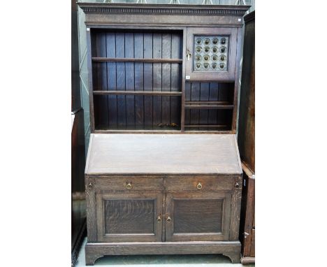 Liberty & Co, an early 20th century oak bureau bookcase, the upper section with open tiered shelves and single door with lead