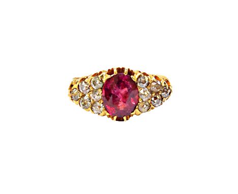 A gold, ruby and diamond set ring, claw set with the oval cut ruby at the centre, between diamond set six stone shoulders, mo