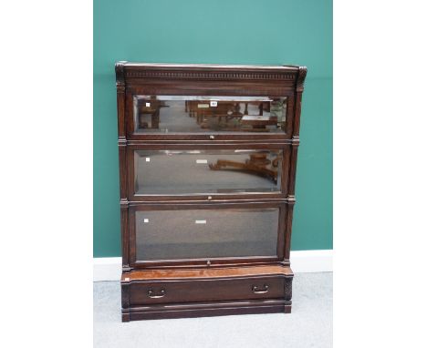 A 20th century oak Globe Wernicke four section bookcase, three with bevelled glazed doors, the lower with drawer, flanked by 