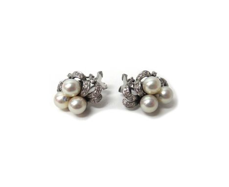 A pair of white gold, cultured pearl and diamond set earclips, each in a scrolling design, mounted with three cultured pearls