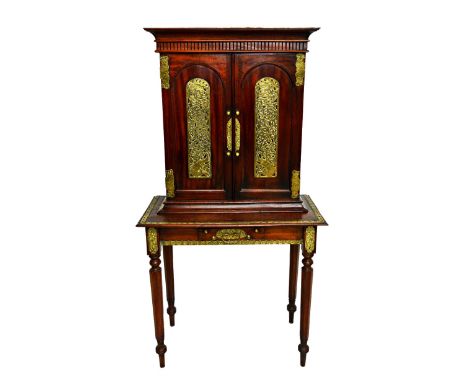 A 19th century brass mounted Eastern hardwood side cabinet, the pair of arch top cupboard doors over single frieze drawer, on