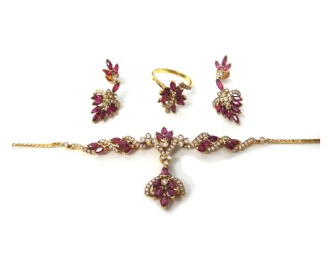 A gold, ruby and diamond set pendant necklace, in a scrolling and foliate design, mounted with marquise shaped rubies and wit