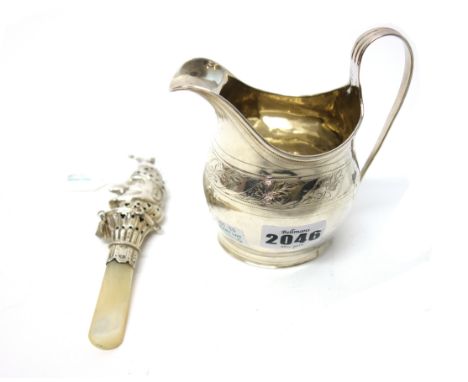 A George III silver helmet shaped milk jug, decorated with an engraved foliate band, London 1802 and a silver baby's rattle, 