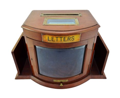 An Edwardian brass mounted mahogany bow front table top telegram/post box, with bevelled glazed central door and fitted lower