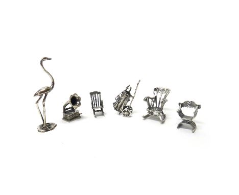 A group of mostly silver miniature ornaments, comprising; a model of a stork, detailed 800, three chairs, including two rocki