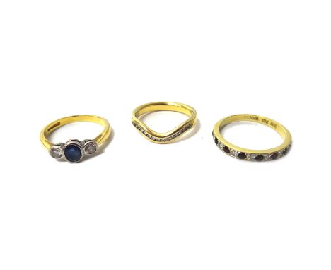 An 18ct gold, sapphire and diamond set three stone ring, mounted with the oval cut sapphire at the centre, between two circul