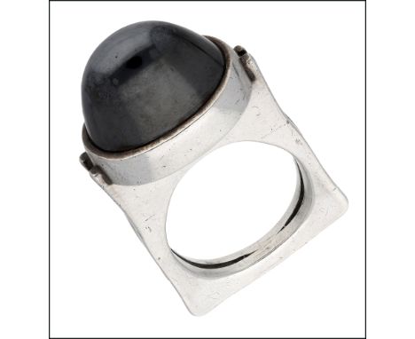 A Danish hematite dress ring by Andreas Mikkelsen, circa 1970, the large hematite cabochon within a collet setting on a recta