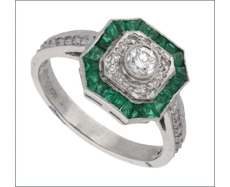 An emerald and diamond dress ring, the octagonal cluster set with brilliant-cut diamonds and calibré-cut emeralds, between di