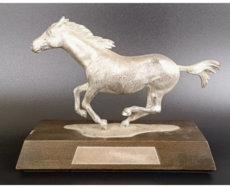An Asprey silver figure of a galloping horse, on a wooden plaque, London 1969, 17 cm wide