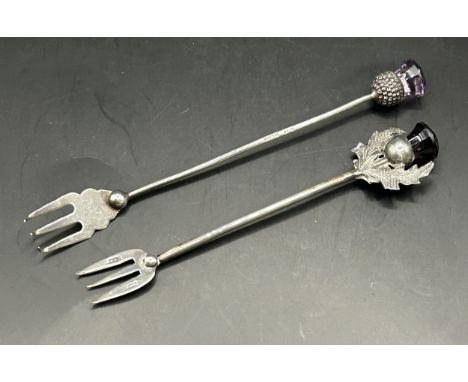 A silver pickle fork, with a thistle finial, Birmingham 1909, and another similar (2)