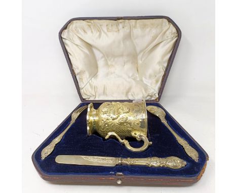 A Victorian matched silver gilt mug and christening set, the mug decorated dogs and inscribed, London 1852, 11 cm high, cased