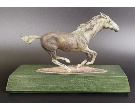 An Asprey silver figure of a galloping horse, on a wooden plaque, London 1969, 20 cm wideHallmarks to the right very light