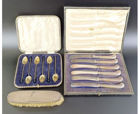 A set of six George V silver and enamel coffee spoons, cased, a set of six pistol handle butter knives with silver handles an