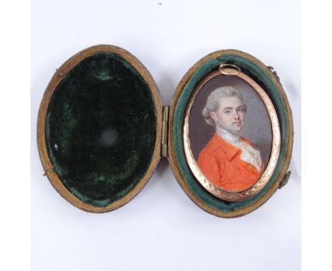 A Georgian miniature watercolour on ivory, portrait of a young gentleman wearing a red coat, unsigned, unmarked engraved gold