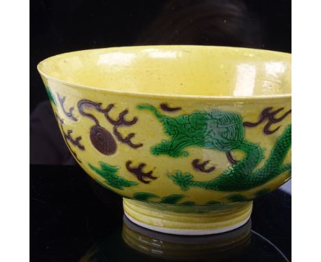 A Chinese yellow-ground Dragon bowl, depicting dragons chasing a flaming pearl, 6 character Kangxi mark to base, diameter 12c