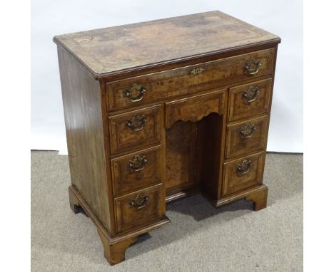 A Georgian walnut kneehole desk of small size, quarter veneered and feather-banded top, with drawers below and alcove cupboar