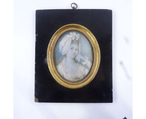 A 19th century miniature watercolour on ivory, head and shoulders portrait of a lady wearing a frilled mob cap, unsigned, in 