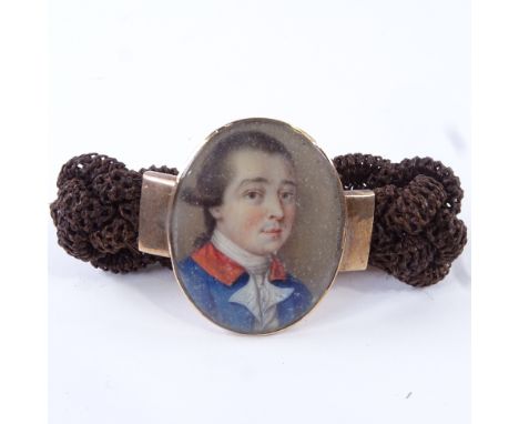 A Georgian woven hair bracelet with central miniature watercolour portrait on ivory, depicting a gentleman wearing a blue and