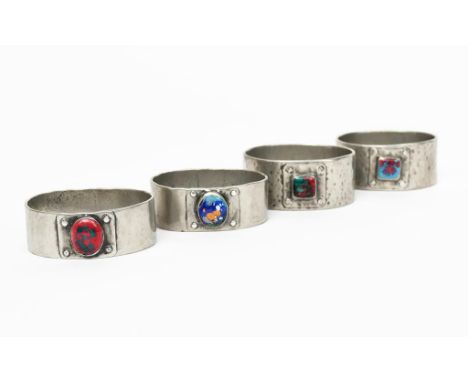 Four pewter and enamel napkin rings, each elliptical, hammered form with coloured enamel panel, unsigned, 5.2cm. wide, (4)