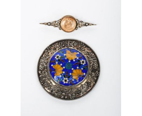 A silver brooch by Winifred Whitside, originally half a buckle, circular with chased band of scrolling foliage, the centre wi